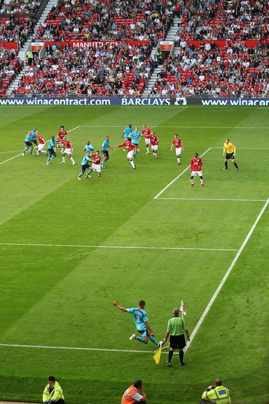 Player taking a corner kick next to the corner flag